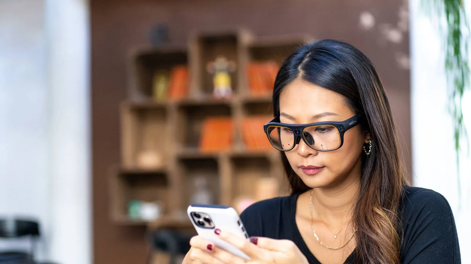 Kobieta w okularach Tobii Pro Glasses 3 korzysta ze smartfona