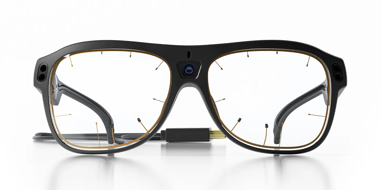 Tobii Pro Glasses 3 od przodu — kamera sceny nad nosem, w szkłach widoczne miniaturowe elementy eye trackingu, z prawej przewód