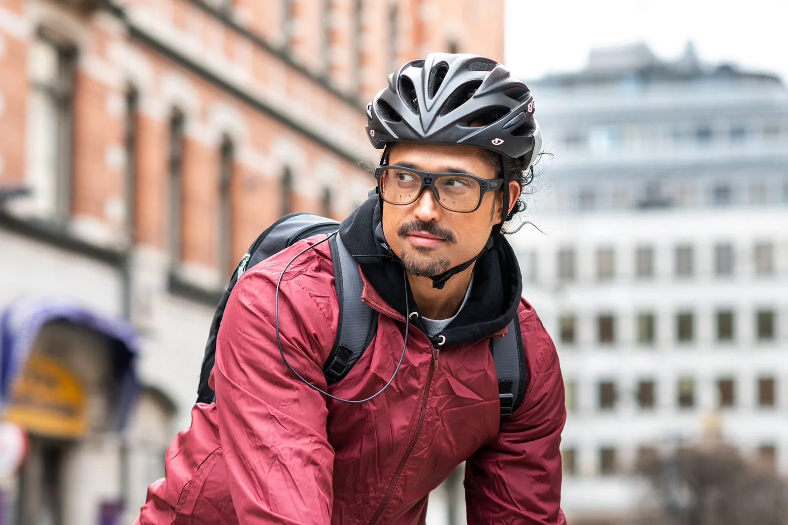Rowerzysta w kasku i okularach Tobii Pro Glasses 3 na ulicy miasta