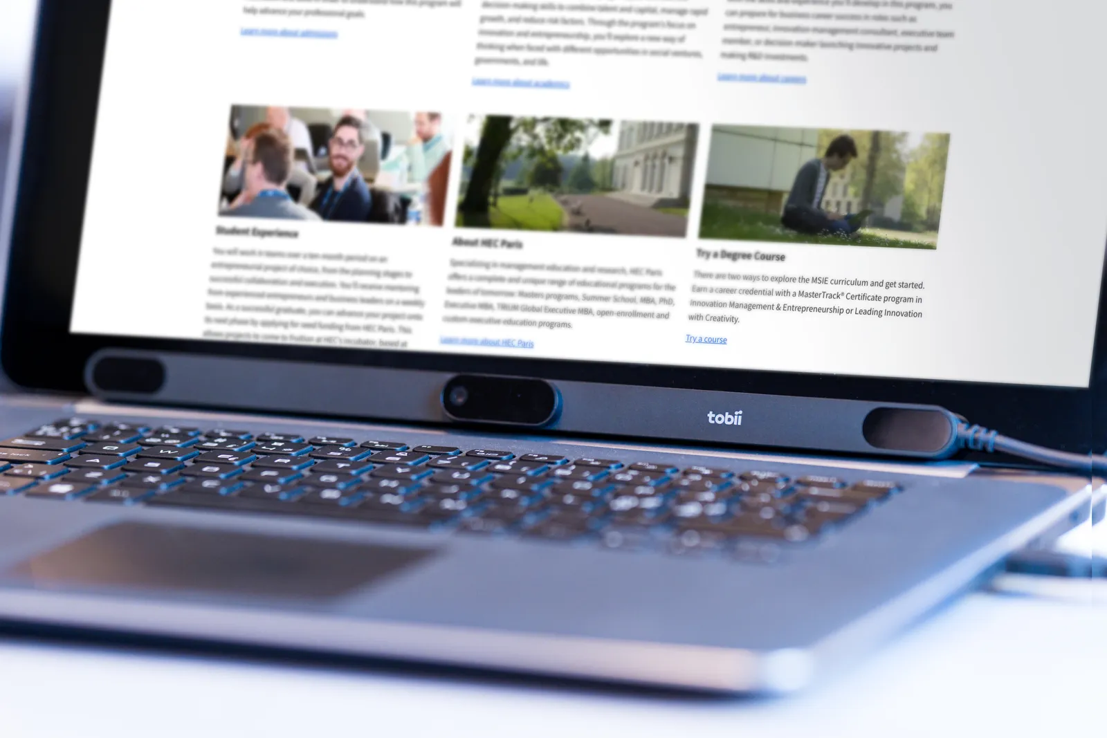Laptop ze stroną internetową uczelni; pod ekranem zamocowana listwa Tobii Pro Spark
