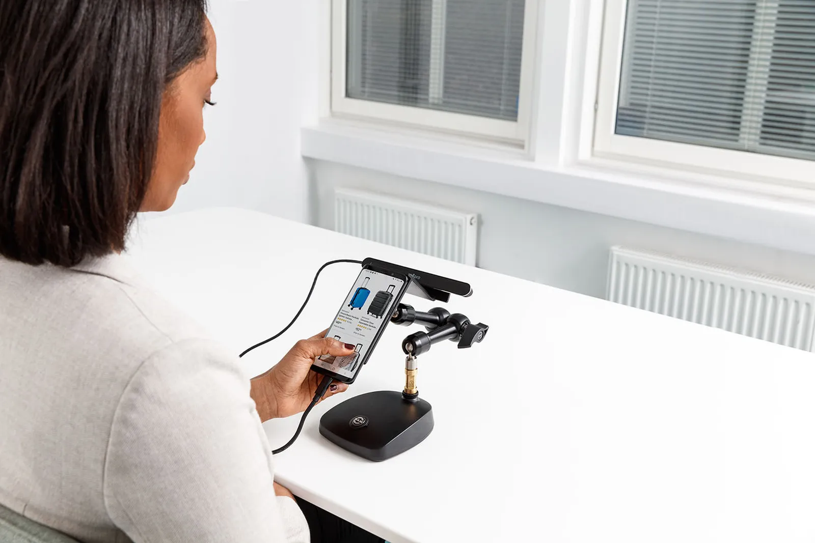 Uczestniczka testuje sklep internetowy na telefonie zamocowanym w Mobile Testing Accessory z listwą Tobii Pro Spark