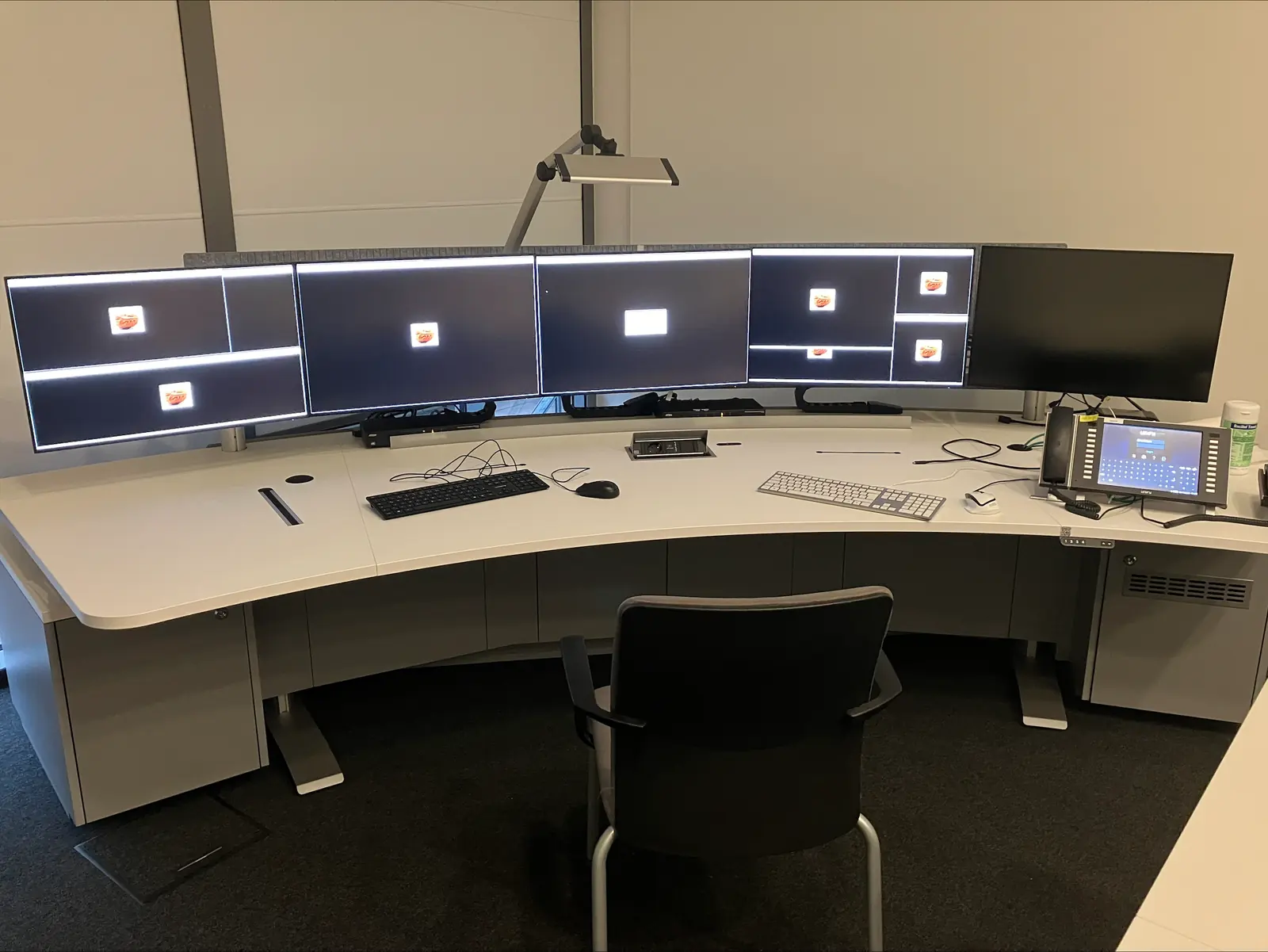 A control room workstation: an operator desk with a row of monitors