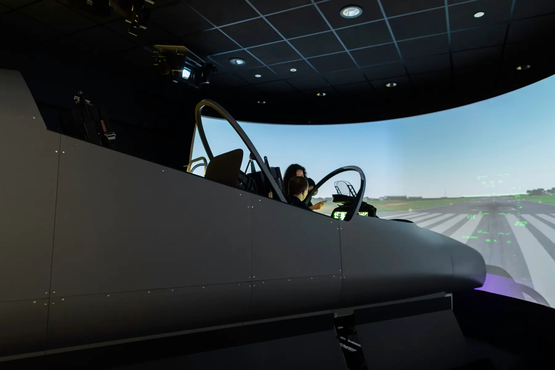A flight simulator cockpit in front of a panoramic screen showing a runway — a typical multi-sensor research setup